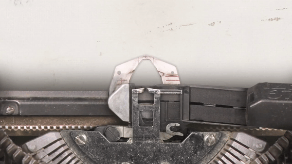 Animação mostrando as hastes mecânicas de uma máquina de escrever se chocando, ilustrando a causa do travamento.